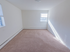 A plush carpeted bedroom with two windows and baseboard heating at Evergreen Club apartments for rent