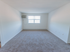 Living room with air conditioning unit and plush carpeting at Evergreen Club apartments for rent in Broomall, PA