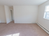Living room with baseboard heating and a window letting in light at Evergreen Club apartments for rent