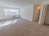 Large living room with a sizable window, coat closet, and plush carpeting at Evergreen Club apartments for rent in Broomall, PA