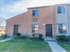 Exterior of red brick townhome complex on a sunny day in Woodbury, NJ