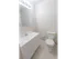 White sink and vanity in bright bathroom with large mirror