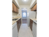 Galley kitchen with brown cabinets and white appliances in Woodbury, NJ townhome for rent