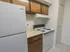 White stove and fridge in apartment kitchen with pantry closet
