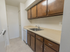 Wood cabinets with silver handles and cream colored countertop