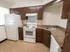 Model kitchen with wood cabinets and modern appliances at Winslow House Apartments in Blackwood, NJ.