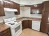 Model kitchen with wood cabinets and modern appliances at Winslow House Apartments in Blackwood, NJ.