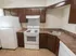 Model kitchen with wood cabinets and modern appliances at Winslow House Apartments in Blackwood, NJ.
