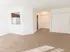 Carpeted living room looking towards the kitchen with a breakfast bar at Winslow House Apartments in Blackwood, NJ.