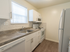 Model kitchen with tiled flooring, wood cabinets and modern appliances at Wyntre Brooke apartments in West Chester, PA.