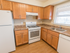 Model kitchen with wood cabinets and modern appliances at Polo Ridge apartments in Burlington, NJ.
