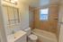Model bathroom with vanity sink, toilet and tiled tub shower at Paoli Place Apartments in Paoli, PA.