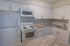 Model kitchen with modern appliances and a tiled backsplash at Rosetree Crossing Apartments in Media, PA.