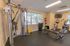 Fitness center with treadmills, ellipticals, weight machines and dumbbells at Rosetree Crossing Apartments in Media, PA.