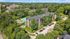 Aerial View of Main Line Berwyn with apartment building, pool, and parking lot surrounded by trees