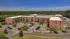Panoramic aerial view of a serene apartment complex surrounded by lush greenery and ample parking space.