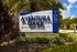 Entrance sign for Aventura Oaks apartment homes surrounded by lush greenery.