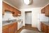 Charming kitchen with warm wooden cabinetry, sleek countertops, and modern appliances, perfect for culinary creativity.