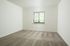 Bright room with plush carpet, large window with blinds, and serene natural light.