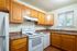Charming kitchen with warm wooden cabinets, modern appliances, and bright natural light, perfect for culinary creativity.