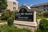 Inviting Cedar Tree Village Apartments sign nestled in lush greenery, offering a glimpse of charming residential buildings.