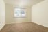Bright and inviting room with plush carpet and large window offering serene views.