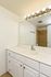 Bright and elegant bathroom with a large mirror, modern light fixtures, and sleek white vanity.