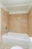 Elegant bathroom featuring a modern, tiled shower and bathtub with warm beige hues.