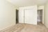 Bright and spacious bedroom with plush carpeting, featuring a large closet and easy access to the adjacent bathroom.