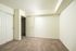 Bright and inviting apartment bedroom with plush carpeting, sleek white closet doors, and neutral walls, perfect for a modern ambiance.