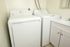 Modern laundry room with a sleek washer and dryer set adjacent to a stylish vanity sink.