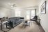 Bright and inviting living room showcasing modern gray sofas, stylish coffee table, and chic accent chairs, perfect for relaxation and entertainment.
