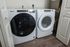 Sleek laundry room featuring modern Whirlpool washer and dryer set on elegant wood flooring.