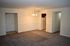 Inviting living area with plush carpet, ambient lighting, and a glimpse of the kitchen, perfect for cozy gatherings.