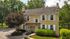 Charming two-story home with classic shutters and lush greenery, set in a peaceful suburban neighborhood.