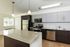 Modern kitchen with sleek stainless steel appliances, elegant pendant lighting, and a spacious island countertop.