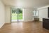 Bright and airy living space with elegant wooden flooring, large sliding glass doors, and scenic outdoor views.