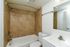 Elegant bathroom featuring a sleek bathtub combined with stylish beige tiled walls and a modern white vanity.