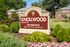Inviting Knollwood Apartments sign surrounded by lush greenery and vibrant flowers, offering a serene living environment.