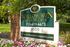 Charming Willow Run Apartments sign surrounded by vibrant flowers and lush greenery, offering a welcoming entrance.