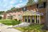 Charming brick townhouse with inviting outdoor space and lush green surroundings.