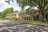 Charming two-story apartment buildings surrounded by lush greenery and shady trees, offering a serene and inviting neighborhood vibe.