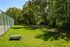 Inviting green space with a fenced dog park, perfect for outdoor recreation and relaxation amidst lush trees.