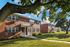 Charming brick apartment buildings nestled in lush greenery with inviting entrances and tree-lined paths.
