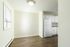 Bright and inviting dining area with elegant wood flooring adjacent to a modern kitchen with crisp white cabinetry and sleek appliances.