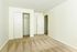 Spacious bedroom with plush carpet and ample closet space, featuring clean white walls and a modern door design.