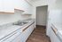 Bright and modern kitchen with sleek countertops, ample cabinet space, and elegant wood flooring.