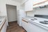 Modern kitchen with sleek white cabinetry, elegant countertops, and a pristine electric stove, perfect for culinary creativity.