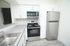 Modern kitchen with sleek stainless steel appliances, white cabinetry, and elegant subway tile backsplash.