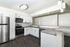 Modern kitchen with sleek stainless steel appliances, elegant white cabinetry, and a spacious countertop featuring contemporary lighting.